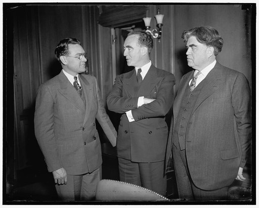 In auto strike limelight. Washington D.C. Labor Secretary Frances Perkins with Governor Frank Murphy of Michigan were in another conference today with labor leaders in an effort to settle the auto strike situation. This picture was made before the meeting got under way. Shows, left to right: Homer L