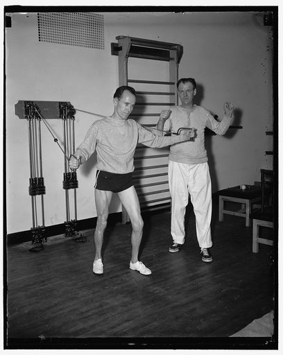 Weights and measures. Washington D.C. Its measures on the House [...] but weights in the House gymnasium that's keeping the members of the 75th session interested these days. Rep. Joe Hendricks, of Florida, is shown building up his muscles with the pulley weights, as Pete Henderson, instructor, look