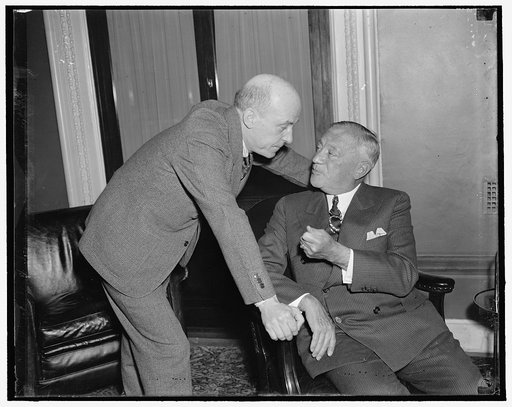 Labor relations whispers. Washington, D.C., April 5. Senator Robert F. Wagner, (right) of New York, author of the Wagner Labor Relations Act, holds a last minute confab with Rep. William P. Connery, Jr., of Massachusetts, who sponsored the legislation on the house, as they anxiously awaited the Supr