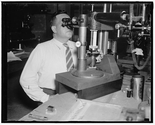 Interferometer tests standard gages for automobile manufacturers. Washington, D.C. May 28. I.J. Fullmer of the Bureau of Standards is shown with an interferometer by means of which differences in length are measured in terms of wave-lengths of light to the millionth of an inch. A four-inch square pr