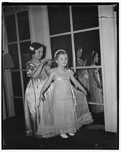 Congressional children's party Washington, D.C. May 29. Photographed while attending the annual children's party given by the Congressional Club of Washington were Joan Johnson, daughter of the congressman from Oklahoma, Mr. and Mrs. Jed Johnson, combing the hair of Sara Garrett, daughter of Rep. an