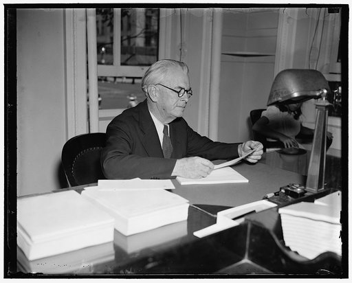 New member U.S. Employees' Compensation Commission. Washington, D.C., June 5. John J. Keegan was today sworn in as a member of the United States Compensation Commission. He is pictured at his desk in the commission offices, 6/5/37