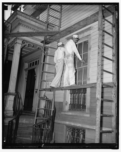 A.F. of L. paints home of John L. Lewis. Washington D.C., July 14. John L. Lewis Head of the C.I.O. is having his newly purchased home in Alexandria, VA reconditioned by the members of the American Federation of Labor his rival in the labor disputes. Photo shows two of the A.F. of L. painters at wor