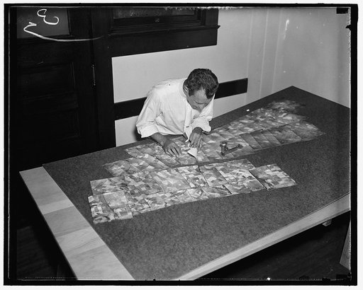 $3,000,000 map. C.E. Kowaloczyk, AAA worker, laying out the finished photographs for the map, after beign correctly fitted they are pieced together for the completed map, 7/28/37