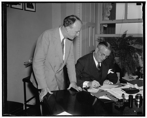 Black confirmed by Senate. Washington, D.C., Aug. 17. The new Associate Justice of the Supreme Court, Hugo L. Black looks calmly on as Col. Edward A. Halsey, Secretary of the Senate, affixes his signature as a finishing touch to the Senate's confirmation of the Alabama Senator to the nation's highes