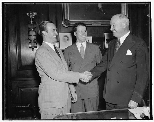 Farley meets new leader of young democrats. Washington, D.C. Aug 25. Newly elected president of the Young Democrats of America, Pitt. T. Maner, shakes hands with Jim Farley, while John P. Kohn, Jr., Maners campaign manager, looks on