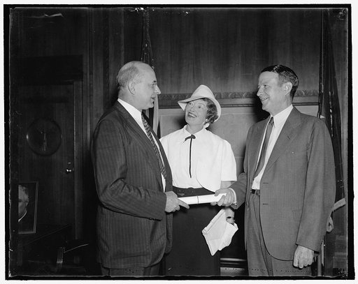 Receives Commission as Special Assistant to Attorney General. Washington, D.C. Aug. 30. Vincent M. Miles, (right) former member of the Social Security Board, receiving his commission as Special Assistant to the Attorney General from Stanley F. Reed, U.S. Solicitor General. Mrs. Miles is in the cente