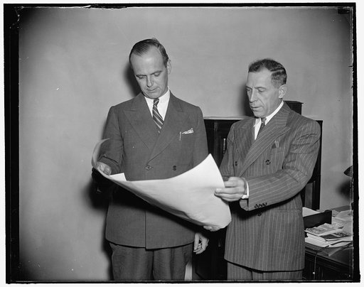 T.A.M. Craven of the Federal Comm. Comm. looking over his new commission with Thomas J. Slowie, Sec. of the commission, right