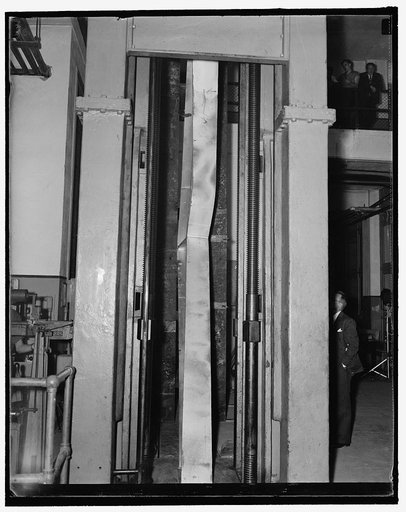 Steel bending. Washington, D.C., Sept. 23. Photo shows the welded steel knees in the 600,000 lb. testing machine at the U.S. Bureau of Standards today, as it buckled under 153,600 lb. maximum load. This rigid steel frame knee was designed to withstand 60,000 lbs. 9/23/37