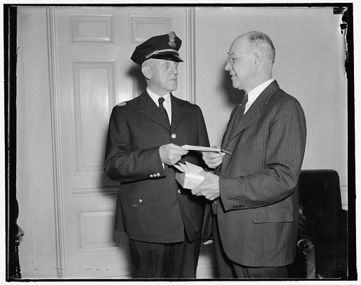 Given purse on retirement. Washington, D.C., Oct. 1. Retired today after 36 years of service at the White House, Liet. Ernest "Larry" Seaman is presented with a purse by Capt. Clarence Dalrymple (left) on behalf of the White House Police Force and members of the Executive Force. The White House Corr