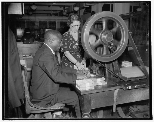 Etta Sullivan and Jimmie Jones operating the canceling machine at the Treasury Department