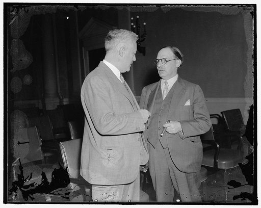 In spotlight as house committee considers tax revision. Washington, D.C., Nov. 4. Lovell Parker, (right) tax expert of the Treasury, appeared before the House Ways and Means Sub-Committee today as it began consideration of a general revision of the Federal Revenue Structure. Parker is shown talking 