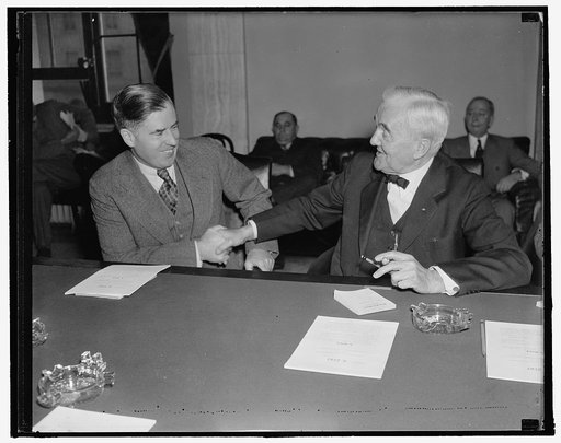 Wallace appears before senate Agri. committee. Washington, D.C., Nov. 17. Secretary of Agriculture Henry Wallace, left; shaking hands with Senator George Norris of Neb. After Wallace explained details of his "ever normal granary" proposal to members of the Senate Agricultural Committee. 11/17/37