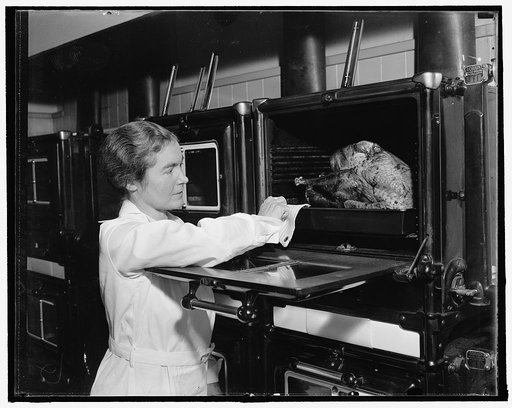 Correct way to bake turkey. Miss Alexander removes the bird from oven and bastes it