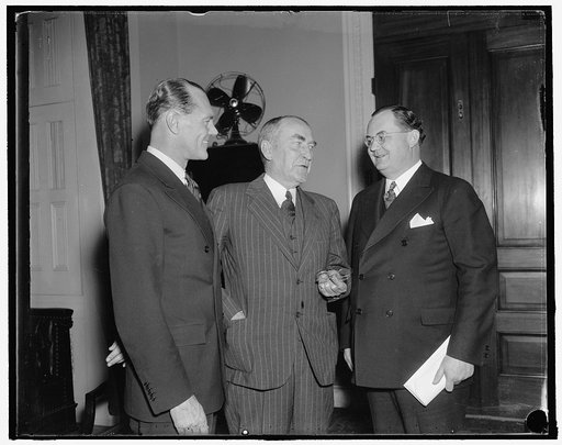 Discuss monetary Questions. Washington, D.C., Dec. 3. James H.R. Cromwell, (left) monetary expert and husband of Doris Duke, Tobacco Heiress, discuss monetary questions with Speaker Bankhead and Rep. Wright Patman of Texas, on a visit to the Capital today. 12/3/37
