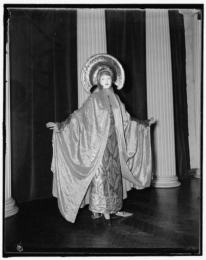 Mrs. [...]Benda, wife of the famous "Benda Masques," in a costume known as the "The Golden Goddess." The masque and costume are both done by Benda