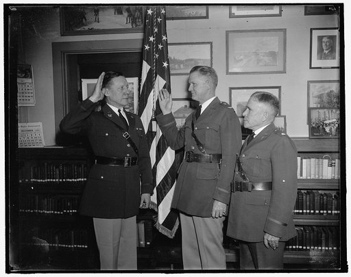 New Chief of Chaplains takes oath. Washington, D.C., Dec. 23. For the first time in the history of the Army a Roman Catholic priest was inducted into office as Chief of U.S. Chaplains. He is Col. William R. Arnold (center) and is shown taking the oath as administered by Maj. Gen. Allen W. Gullion, J