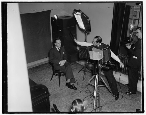 Watches birdie. Washington, D.C., Jan. 7. Edsel Ford, auto magnate, poses for the Harris-Ewing photographer just before he is questioned by the Senate Rail Investigating Committee today, 1/7/38