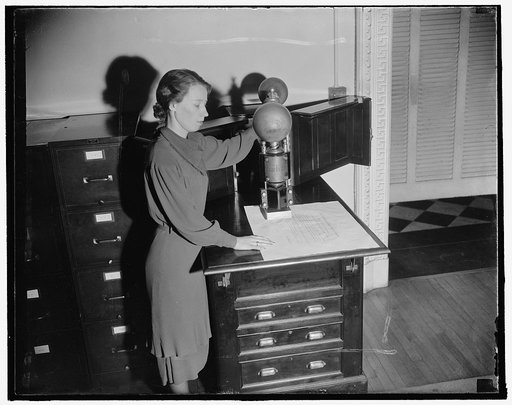 Affixes U.S. seal to all state documents. Washington, D.C., Jan. 8. Mrs. Helen S. Brue, clerk in the State Department's Appointment Section, affixes the great seal of the United States to about 1200 documents per year. This is the only machine in the world which will place the seal of the United Sta