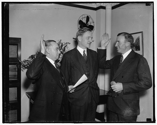 Former Wall Street broker sworn in as member of Security and Exchange Commission. Washington, D.C., Jan. 13. J.W. Hanes, being sworn in as member of the SEC. Hanes is being sworn in by Frank P. Brassor, Secretary to the Commission while William O. Douglas, Chairman of the Commission, center, looks o