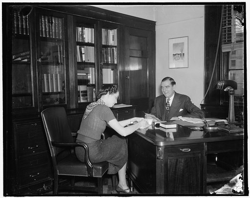 A congressman's day. 10:00 A.M. After reading letters from his home district, Rep. Thomas dictates the answers to his stenographer, 12/31/37