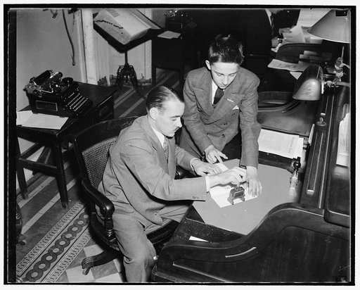 How a bill become a law. Delivered to the chief bill clerk by a page boy, the bill is given a number and sent to the Government Printing Office for printing. William McDermott, chief bill clerk of the house, is shown numbering a bill brought to him by page John Jurgensen