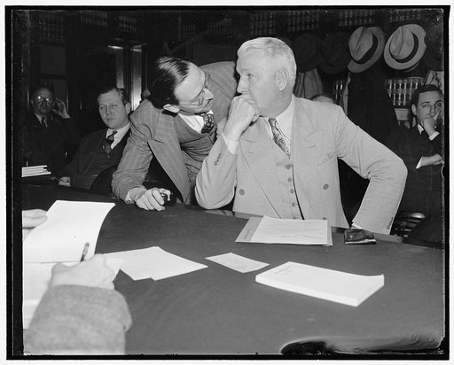 Whispered advice. Washington, D.C., March 31. As the Senate Judiciary Subcommittee opened hearings today on the bill just introduced by Senator Guy M. Gillette (seated) to divorce the marketing of petroleum from the refining production and transportation, P.E. Hadlick, Secretary of the National Oil 