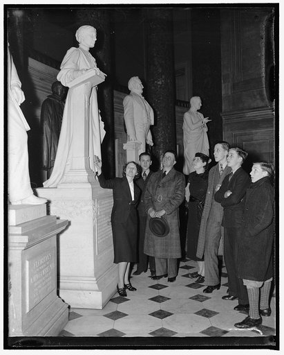 Capitol guides get new uniforms. Washington, D.C., April 2. U.S. Capitol guides appeared for the first time today in their new uniforms of navy blue. The only ornament on the uniform is the badge of silver. One of the few women guides, Miss Olga Rice, is shown wearing the new outfit as she pilots a 