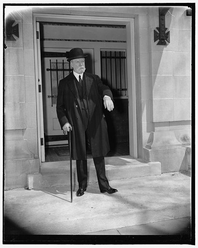 Chief Justice Hughes celebrates his 76th birthday. Washington, D.C., April 11. Chief Justice of the Supreme Court Charles Evans Hughes, was 76 years old today, he is shown leaving his residence to go to the Supreme Court, The Chief Justice is telling photogs not to come in for a close-up. April 11, 
