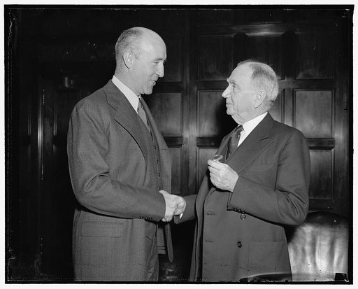 New director of air commerce. Washington, D.C., April 16. Denis Mulligan, Chief of the Bureau of Air Commerce, Department of Commerce, greeted by his boss Daniel Roper, Sec. of Commerce, just after being sworn in as Director of Air Commerce, 4/16/38