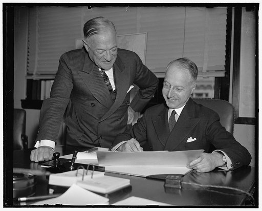All set for construction. Washington, D.C., April 20. While Senator Robert F. Wagner, of New York, the father of modern housing legislation, looks on with pride, Nathan Straus, Chief of U.S. Housing Authority, puts the final OK on the President's approval of $36,657,000 in contracts for housing proj