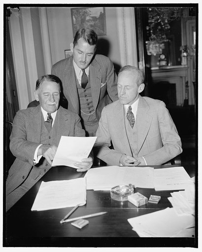 Discuss legislation for U.S. Territories. Washington, D.C., April 28. While not called for testimony, Governors Blanton Winship (left) of Porto Rico, and Lawrence W. Cramer (standing) of the Virgin Islands, conferred with Senator Millard Tydings, Chairman of the Senate Territories and Insular Affair