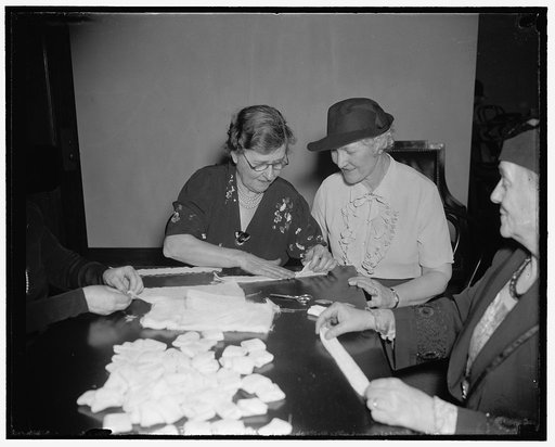 Second lady expert at making Red Cross bandages. Washington, D.C., May 7. Mrs. John N. Garner, (left) wife of the Vice President, teaches the art of preparing Red Cross bandages to Mrs. James F. Byrnes, wife of the Senator from South Carolina, at a meeting of the Senate Ladies club at the Capitol. E