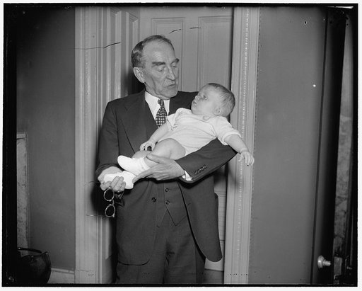 Speaker bestows campaign kiss. Washington, D.C., June 16. Four month old George Donahue O'Brien, son of Rep. and Mrs. George D. O'Brien of Michigan, was greeted with a typical campaign kiss as he met Speaker Bankhead for the first time tonight just before the house adjourned, 6/16/38
