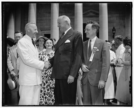 35th Annual Convention of Rural Letter Carriers. Washington, D.C., Aug. 23. Raymond H. Combs, of Churchville. New York. President of the National Association of Rural Letter Carriers, left; congratulated by Postmaster General James A. Farley, upon the opening of the 35th Annual Convention of Rural L