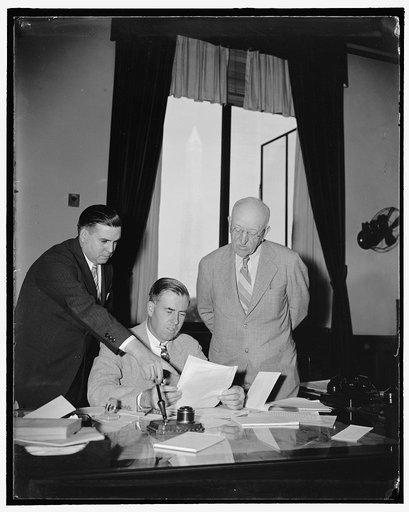 Signing New York milk marketing order Washington, D.C., Aug. 26. Sec. of Agriculture Henry Wallace Center; Commissioner Holton V. Noyes, right; of the New York Department of Agriculture, and F.R. Wilcox, director of the AAA division of marketing and marketing agreements, are looking over the Federal