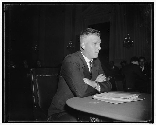 House Committee hears of red activities. Washington, D.C., Oct. 21. Edwin Hughes, a police captain at Flint, Mich. Told house investigators today that a man he knows as a Communist used a sound truck to incite rioting at Flint's Fisher Body Plant in 1937. He is shown as he appeared on the stand, 10/