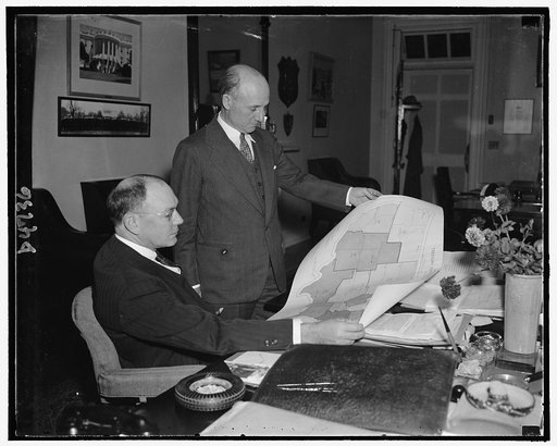 J. Frank Wilson, seated, Chief of USSS, looking over a law enforcement map with Joseph Murphy, Asst. Chief