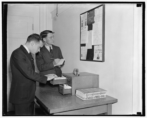 Employees of the Secret Service checking over bulletin board getting the latest criminal news, 10/38