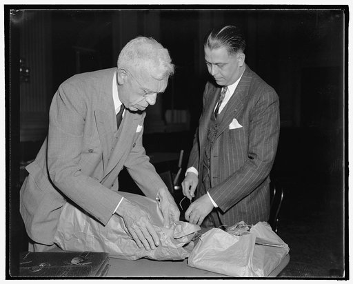 Bridges a Communist, Legion officials charge before House Committee. Washington, D.C., Oct. 24. Harper Knowles, right, Chairman of the Radical Research Committee of the American Legion, and Ray Nimmo, Counsel for the same committee, pack up their mass of evidence after charging before the House Comm