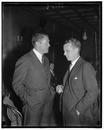 In spotlight at Liquor Advertising Conference. Washington, D.C., Oct. 25. Gene Tunney, left, former heavyweight champion and now Chairman of the board, American Distillers Corp, discusses with Wesley A. Sturgis, newly named Executive Director of the Distilled Spirits Institute, the many problems on 