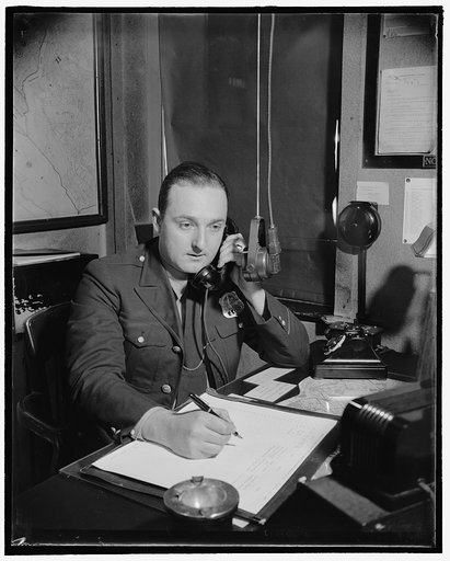 James R. Clement, radio dispatcher receiving a cell by telephone which he will repeat over the microphone before him, 10/38