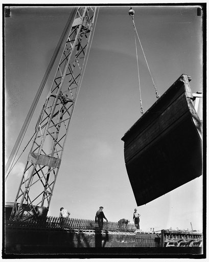 Swinging a form for the concrete high speed basin into place. The workmen are standing in the place where the unique concrete hinges of the arched roof will be
