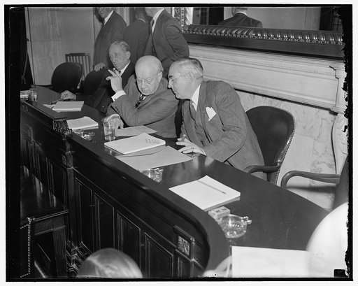 In last minute huddle. Washington, D.C., Nov. 21. Senator Clyde Herring, left, Democrat of Michigan and Chairman of the Senate Finance Subcommittee which began hearings today on profit sharing plans, holds a last minute with a republican member of the committee, Senator Arthur M. Vandenberg of Michi