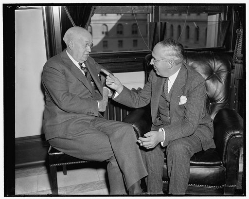 Last minute huddle. Washington, D.C., Nov. 21. Senator Clyde Herring, left, Democrat of Michigan and Chairman of the Senate Finance Subcommittee which opened hearings today on profit sharing plans, holds a last minute conference with a republican member of the committee, Senator Arthur M. Vandenberg