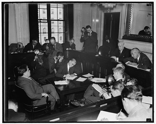 Cameramen set stage for John L. Lewis before senate committee. Washington, D.C., Nov. 30. Amid the flashes of cameramen and while Senators listened attentively, CIO head John L. Lewis today explained his reason for opposing profit sharing systems to the Senate Finance Subcommittee. Labor must depend