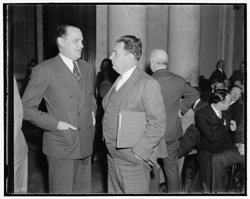 At Monopoly hearing. Washington, D.C., Dec. 1. Dr. Willard Thorp, left, Dun and Bradstreet Economist not with the Commerce Department. Leon Henderson, Secretary of the Joint Monopoly Committee, chat informally as both attended the opening hearing today. They will testify before the Committee tomorro