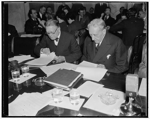 Examine first evidence offered to Monopoly Committee. Washington, D.C., Dec. 1. Senator William E. Borah, left, Republican of Idaho, and Senator William H. Kin, Democrat of Utah, study evidence offered by Isador Lubin, Commissioner of Labor Statistics, U.S. Dept. of Labor, who appeared as the first 