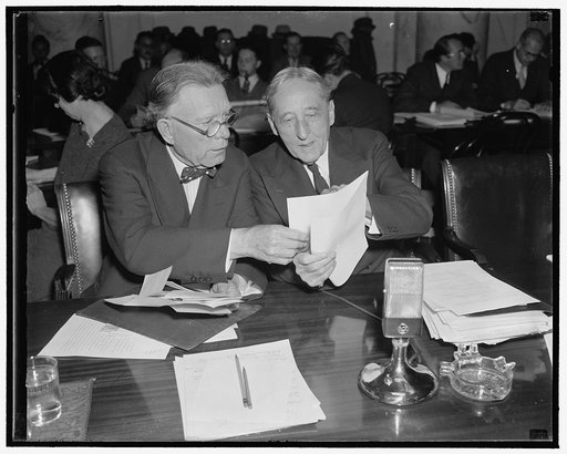 Examine first evidence offered to Monopoly Committee. Washington, D.C., Dec. 1. Senator William E. Borah, left, Republican of Idaho, and Senator William H. Kin, Democrat of Utah, study evidence offered by Isador Lubin, Commissioner of Labor Statistics, U.S. Dept. of Labor, who appeared as the first 