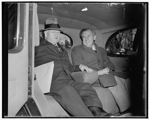 WPA Administrator and ace 'brain truster.' Washington, D.C., Dec. 6. Secretary of Interior Harold Ickes and 'Tommy' Corcoran, the administration's ace - brain truster, pictured leaving the White House today after a conference with President Roosevelt